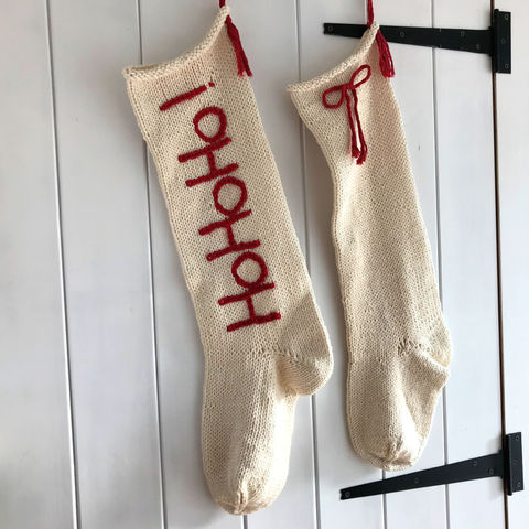 Handknit undyed cream cotton stockings hanging on a wooden door