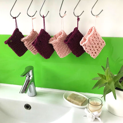 6 different patterns of knit soap savers in berry or peach coloured cotton