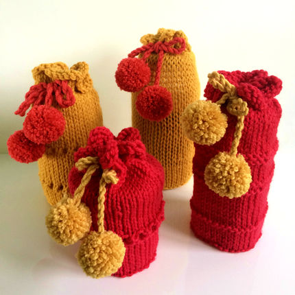 4 knitted jar gift bags in red and gold with pompom drawstrings
