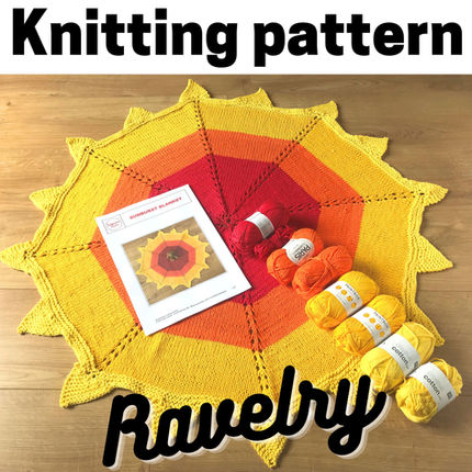 A yellow, orange and red octagonal blanket with 'sunray' points around the edge, laid out with the cotton yarns used to knit it
