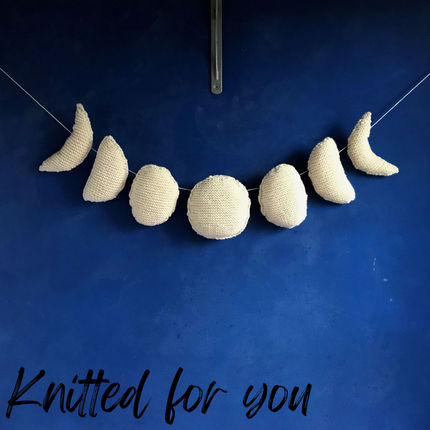 Stuffed phases of the moon shapes threaded on a string as bunting