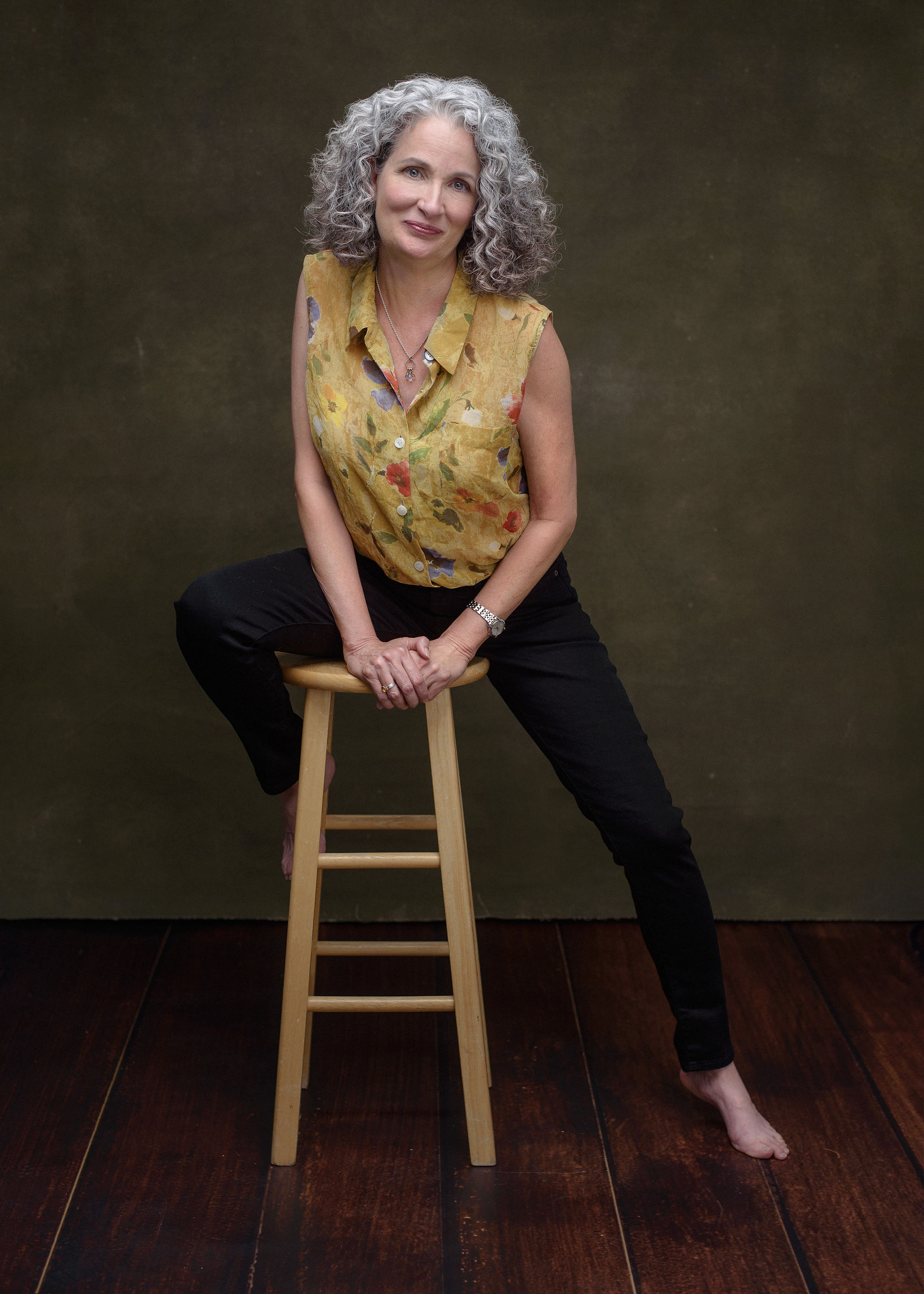 Woman wearing yellow floral blouse and black jeans