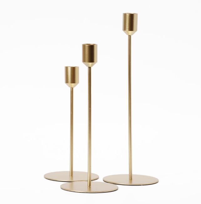 A set of 3 different sized gold candlestick holders designed for tapered candles.