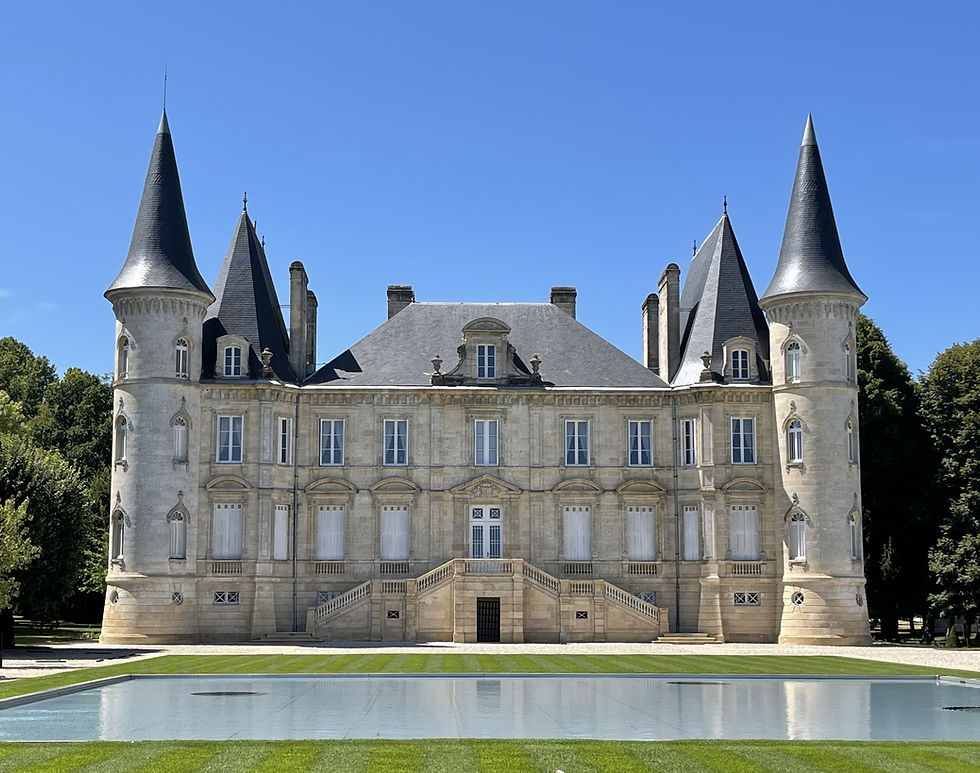 A breathtaking view of Château Pichon Baron captures the essence of this iconic estate with its stunning façade, complete with elegant turrets and spires, reflects beautifully in the tranquil waters of the forecourt's rectangular pond.
