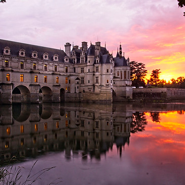 Sunset view of Chateau de Chenonceau reflecting gracefully on the tranquil river. Amidst the captivating scenery of the Loire Valley, this historic castle is surrounded by vineyards, enchanting gardens, and the rich winemaking heritage of the region