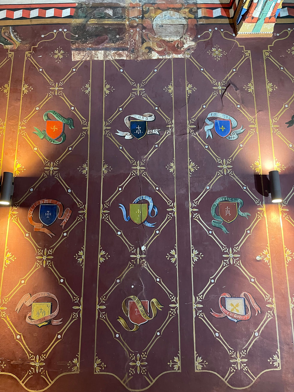 The walls adorned with the coats of arms of various abbots.