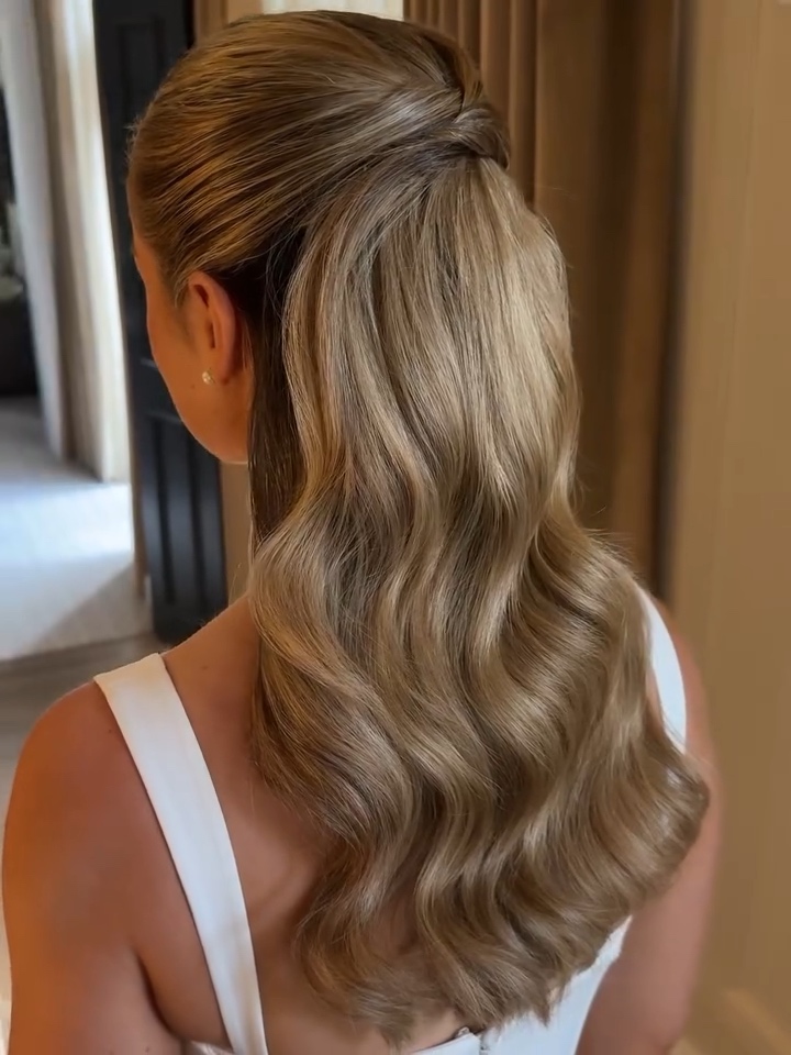 Half-up bridal ponytail with glossy waves