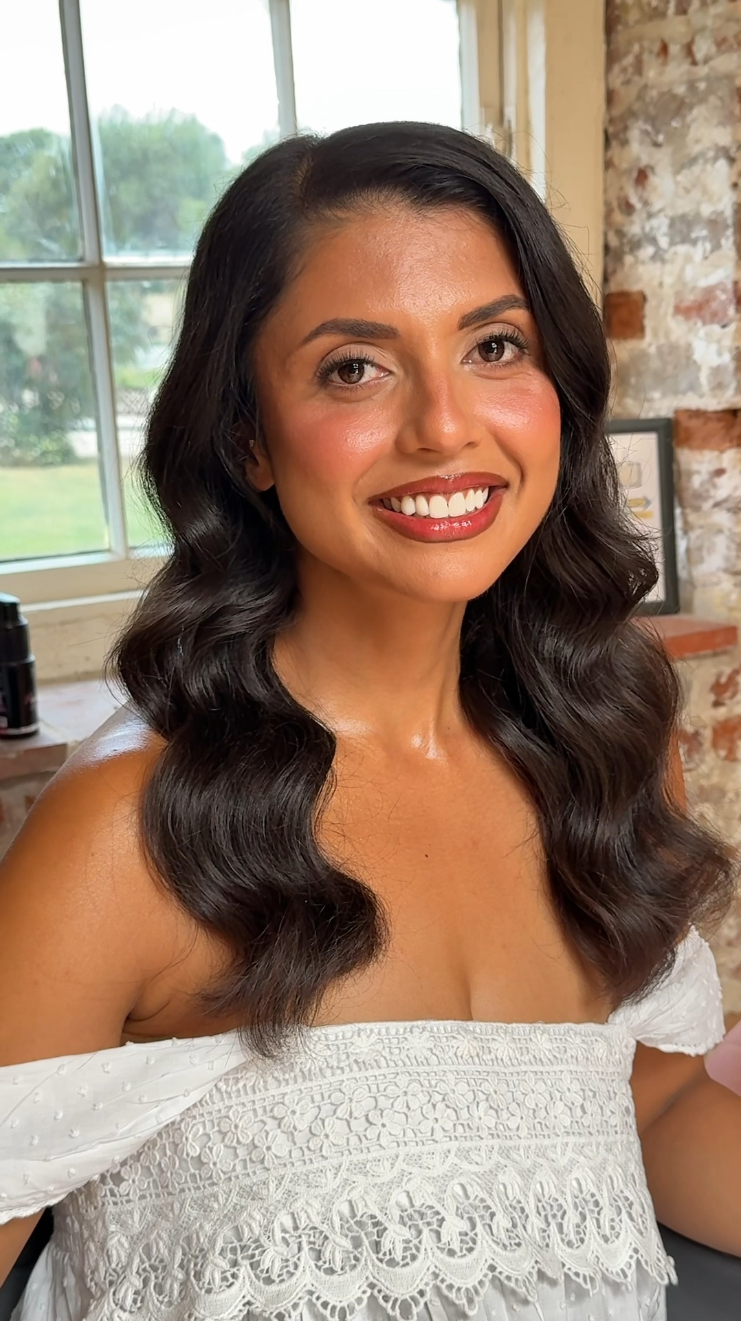 Bride with glossy dark waves and soft glam makeup