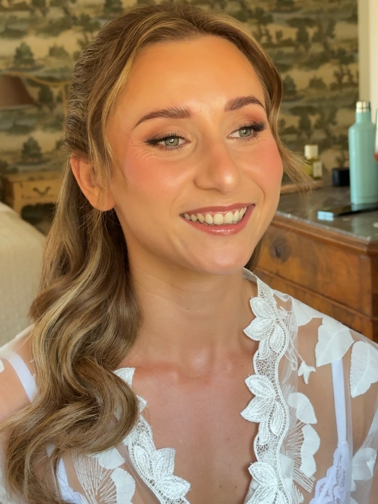 Smiling bride with glowing skin and soft waves