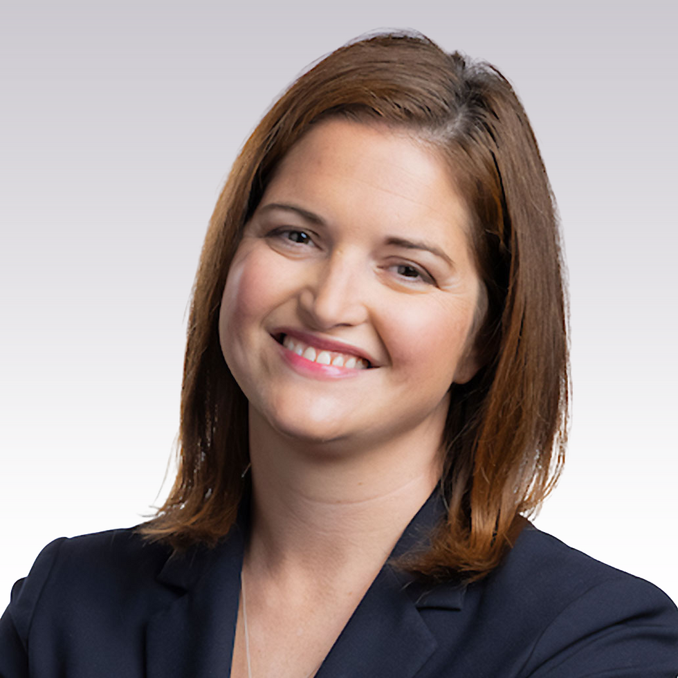 Smiling women, Meghan Healy, with shoulder-length brown hair in a dark blazer on a light gray background, conveying a friendly and professional mood.