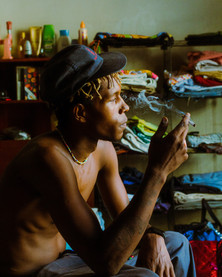 Man relaxes and smokes while watching a movie to take his mind off the everyday stress