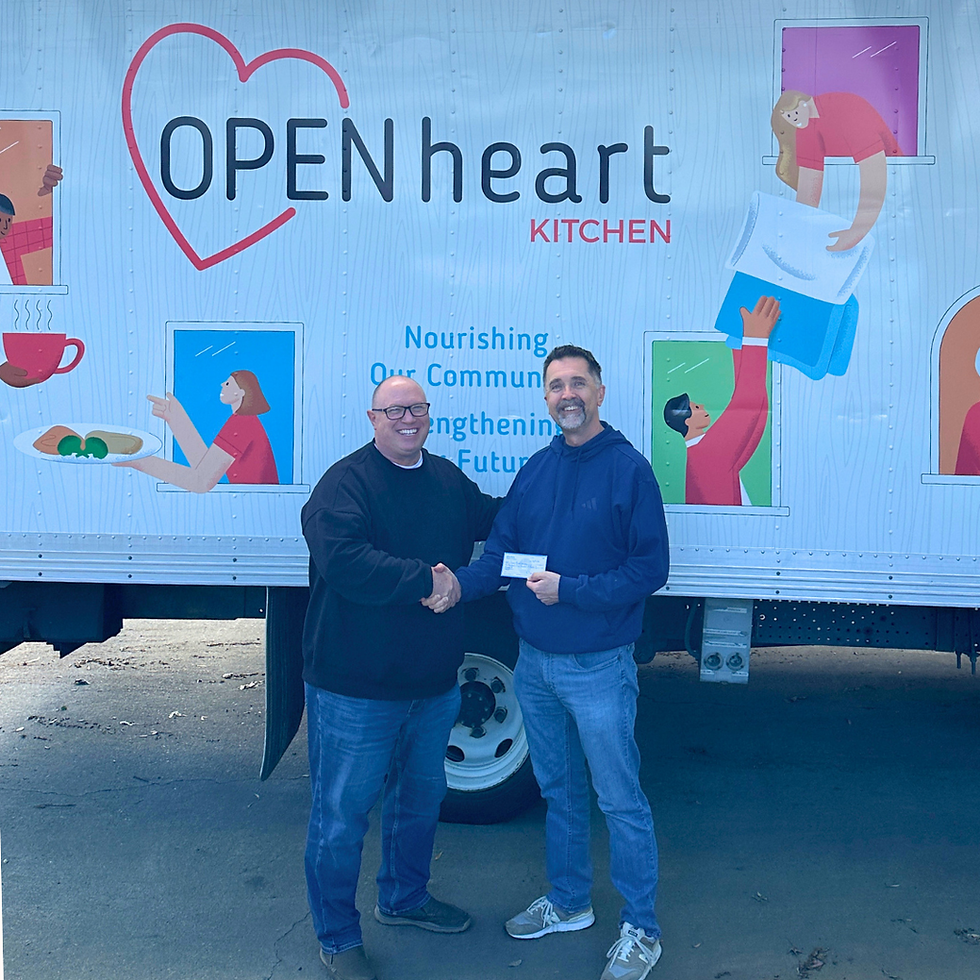 A community supporter presenting a chec to Open Heart Kitchen