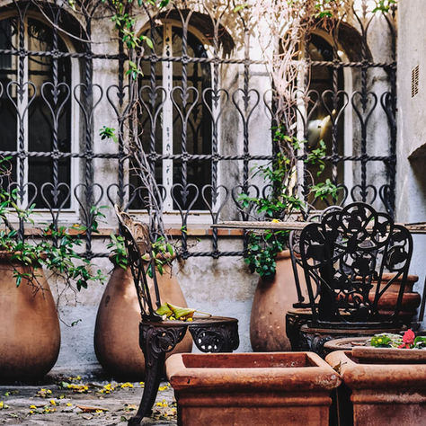 French patio with large pots, railing sand a coffee table
