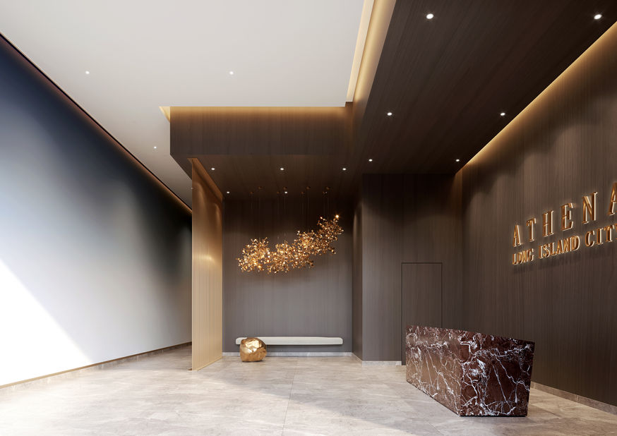 Luxury lobby with bronze accents and feature wall logo at Athena LIC Long Island City