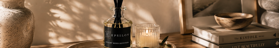 Epsilon Home luxury reed diffuser with black fibre reeds styled in a warm, elegant home interior with natural greenery and so