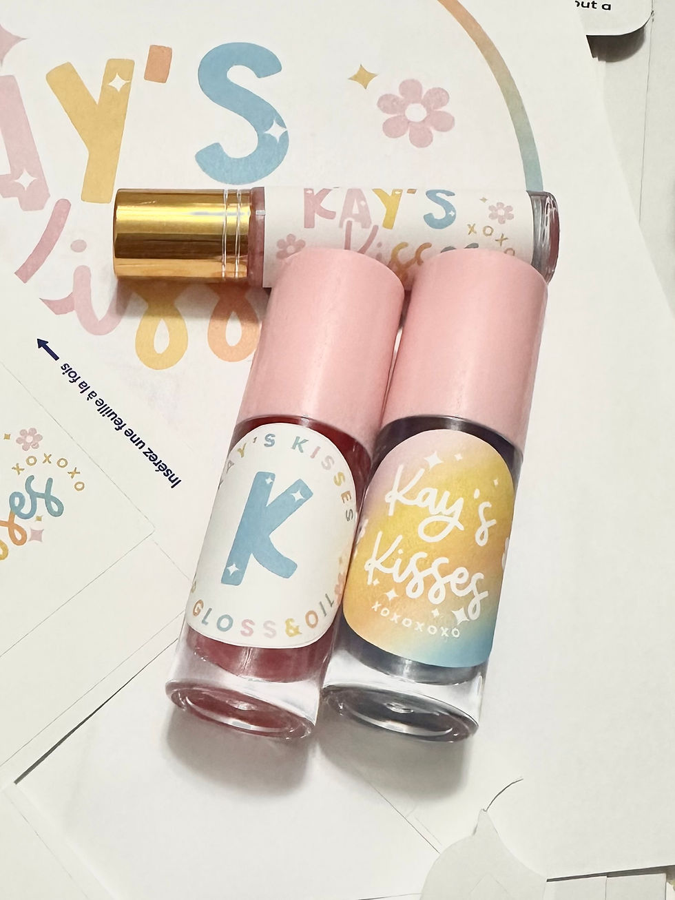 Kay’s Kisses Vanilla Lip Gloss — Kay’s Kisses vanilla lip gloss tubes with pink caps and branded labels