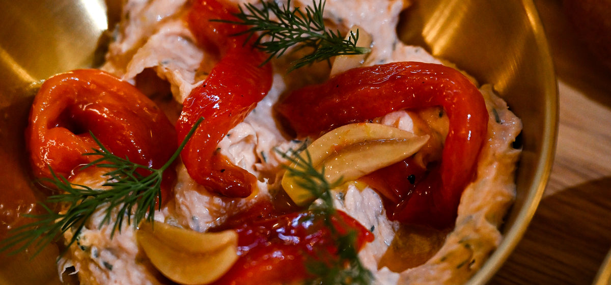 Smoked trout mousse with red peppers, garlic and dill in a gold bowl