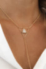 Y-style necklace featuring a gold and silver triangular symbol