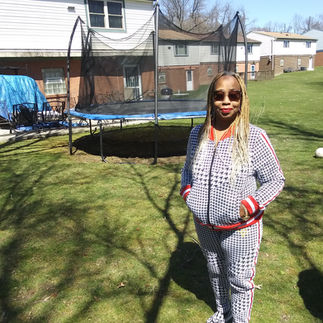 Terry Fuller in the yard of her Glen Hazel home. She received the solar panels visible behind her on her roof through a crowdfunding campaign.