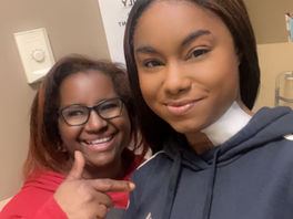 Two women smile at the camera.