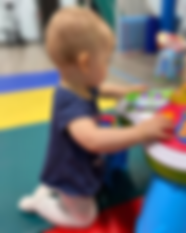 Kneeling at a bench/low table/toy.