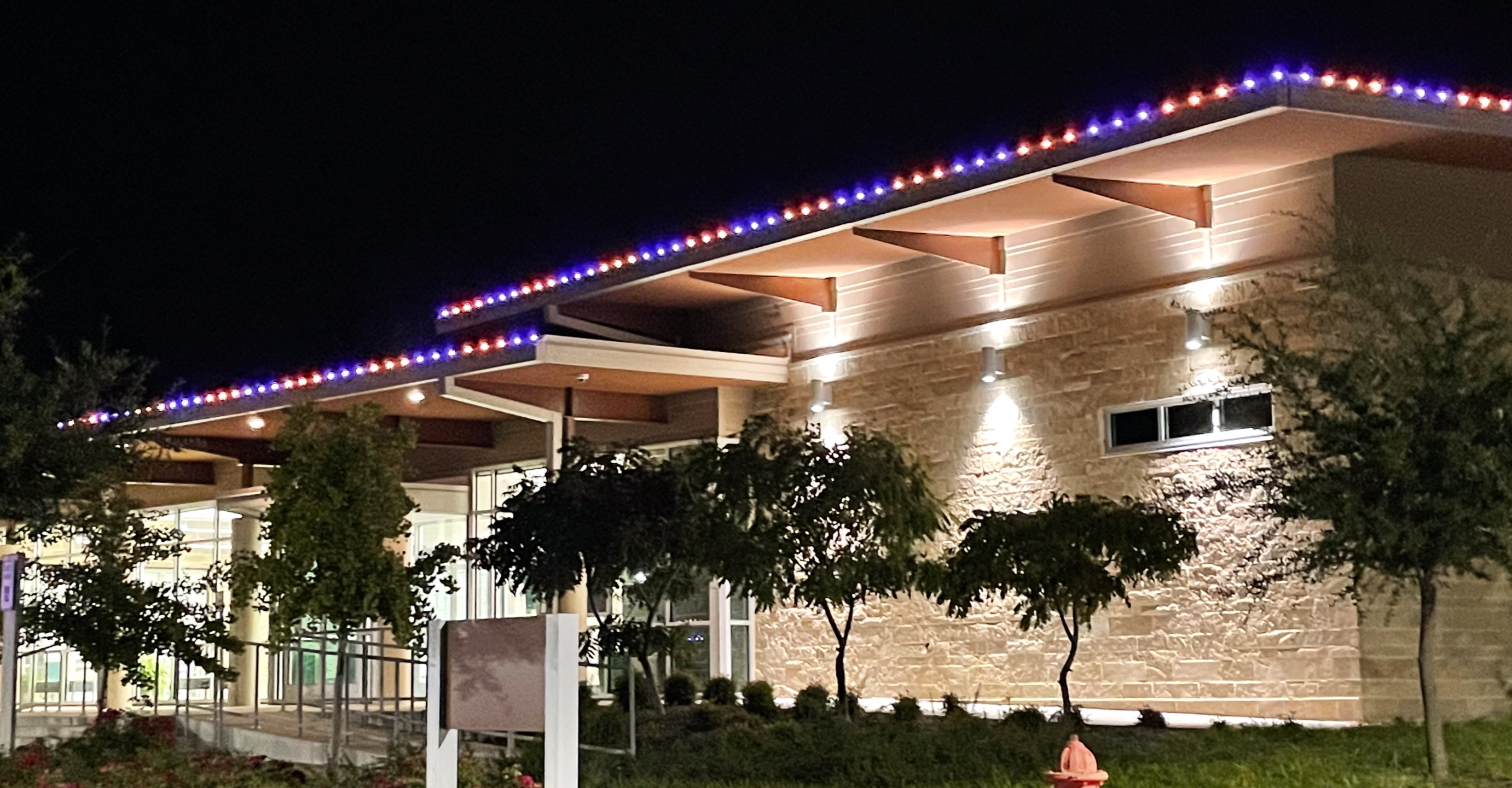 Commercial building with white permanent roofline lighting