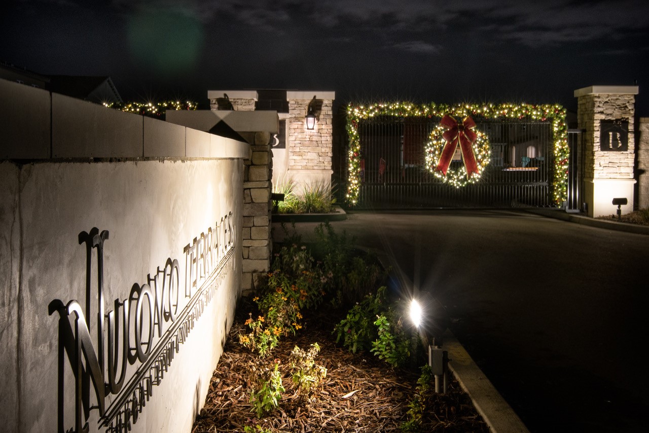 Neighborhood entry wall with a lit wreath in Clovis