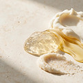 Cream, oil and textured body-care materials on warm porcelain