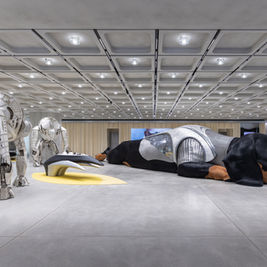 Gentle Monster’s giant animatronic dachshund in chainmail armor at Haus Nowhere Seoul, inside a concrete futuristic gallery.
