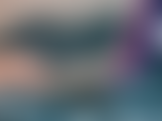 A person working on their laptop while sitting under a cozy blanket.