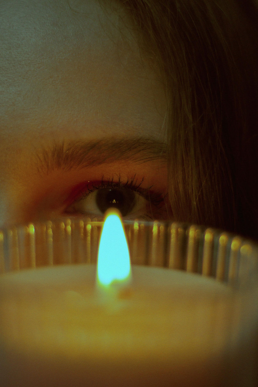 Primer plano de un ojo iluminado por una vela, representando la revelación sin velo del deseo y el voyeurismo en la pornografía (la lámpara de Psique).