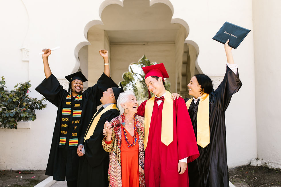 Group of recent graduates in caps and gowns celebrating with arms raised