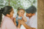 Latino parents holding and smiling with toddler daughter, representing Latino mental health support in Western Massachusetts