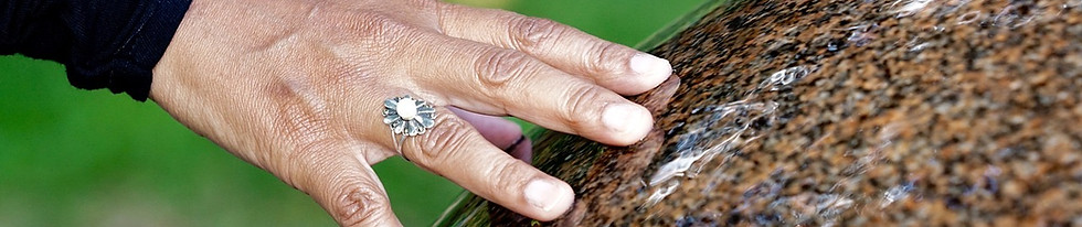 Hand mit Ring auf Stein