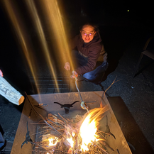 Guest roasting marshmallows over the outdoor fire pit at Cedaredge Lodge