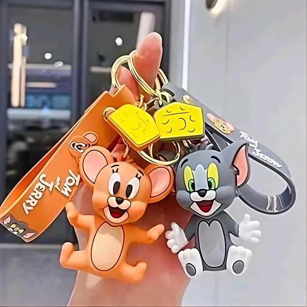 Hand holding two Tom and Jerry keychains with cheese charms