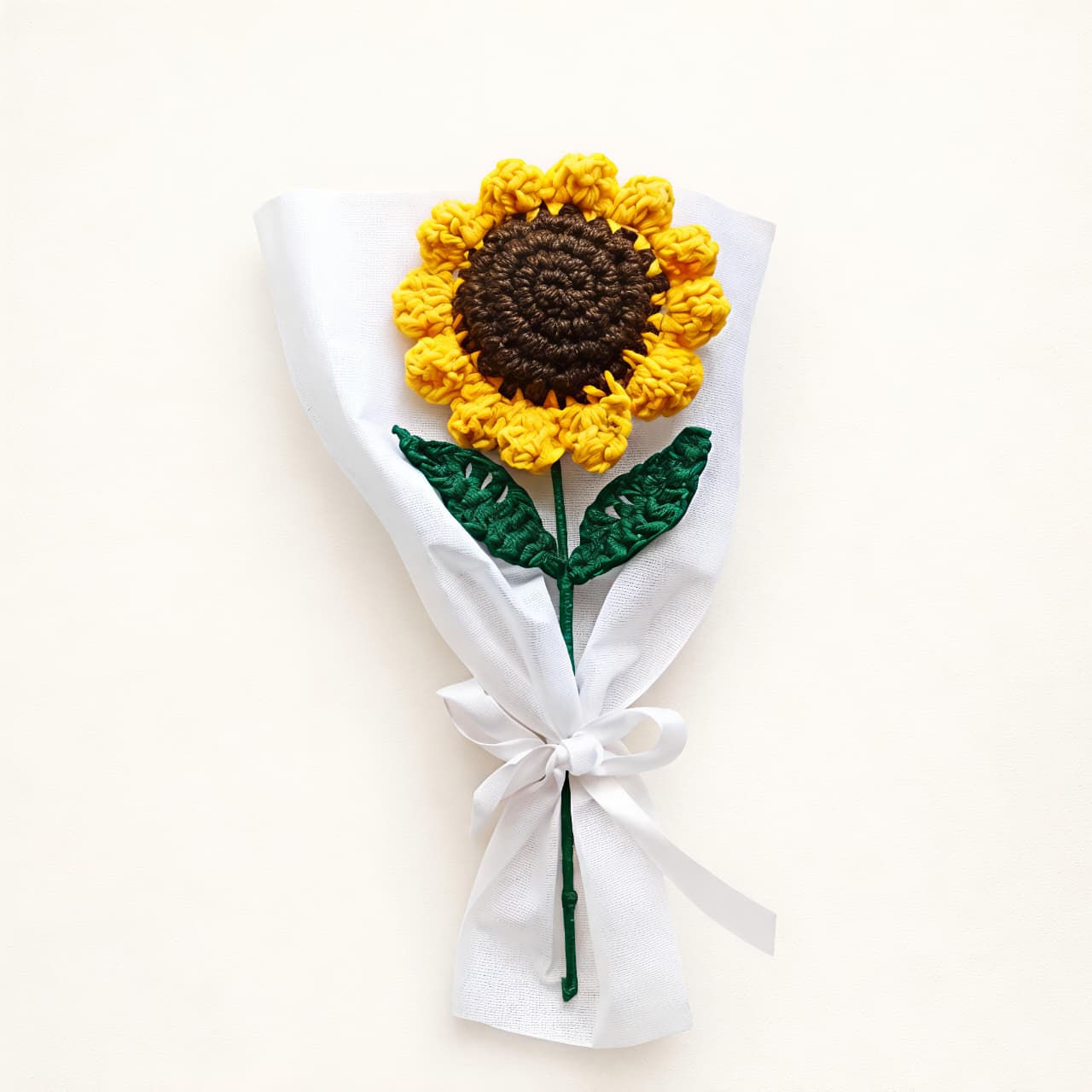 Crocheted sunflower in white wrapper