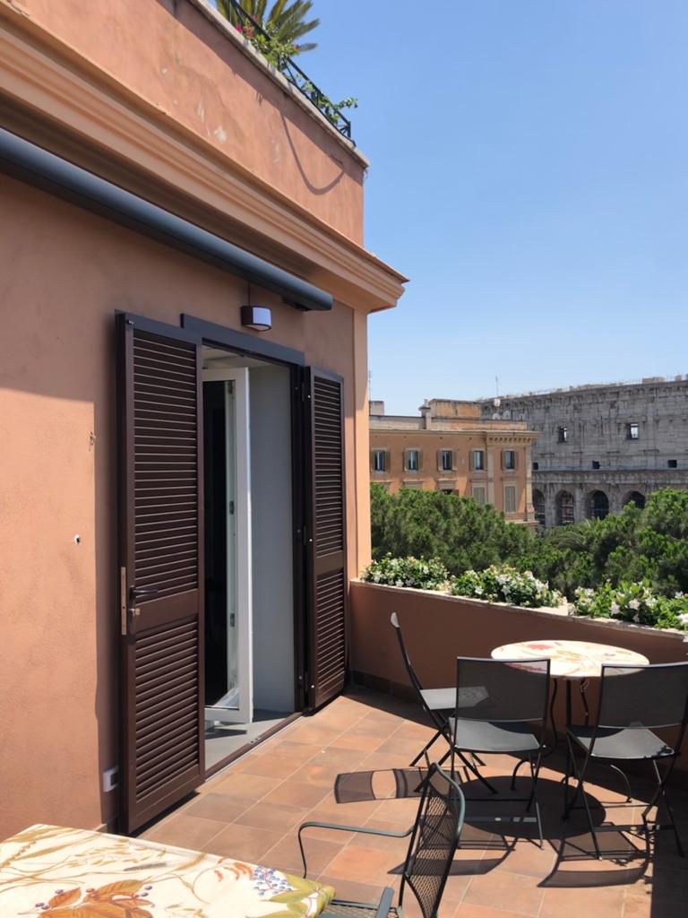 Porte-finestre con persiane su terrazzo, centro storico di Roma con vista sul Colosseo