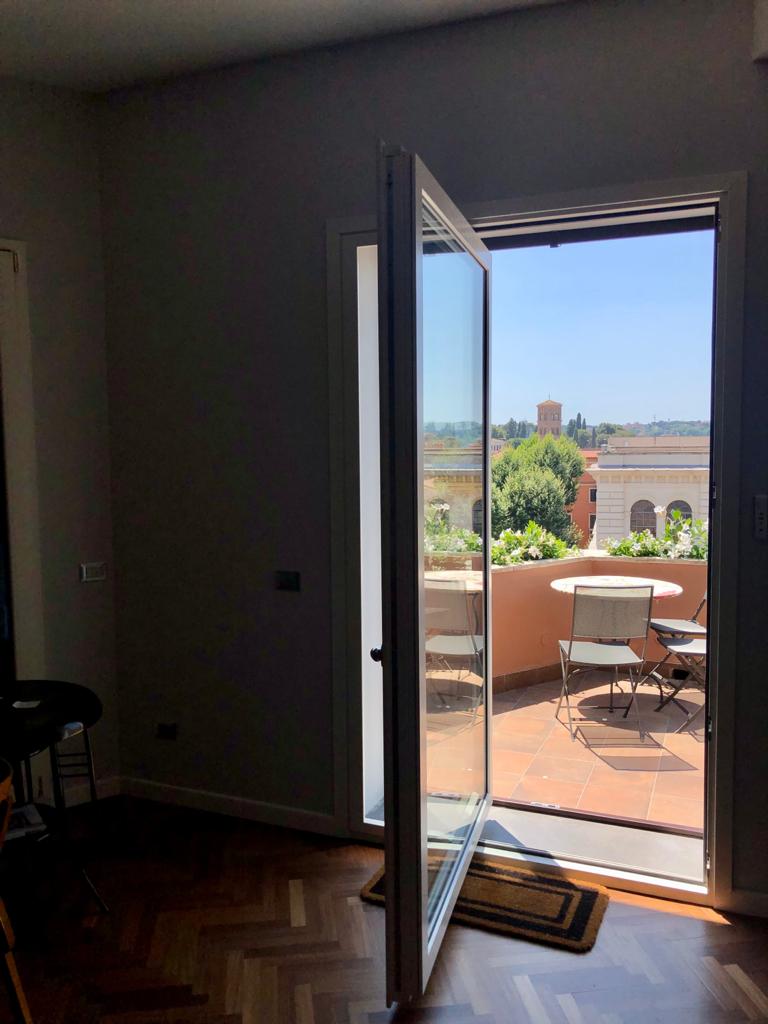 Serramenti scuri su terrazzo con vista sui tetti di Roma