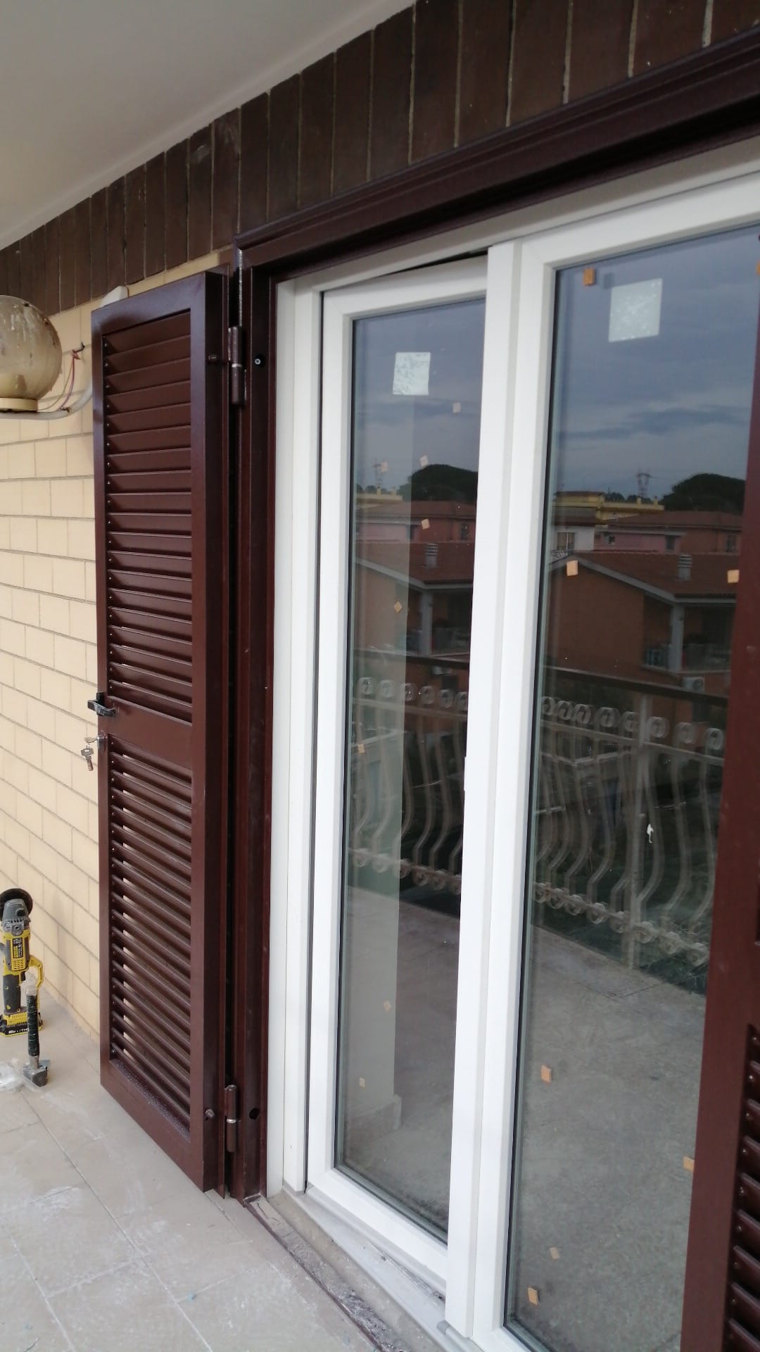 Dettaglio di persiana e serramento in PVC bianco su balcone