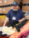 Dustin at work at goodwill sorting cloths into a bin.