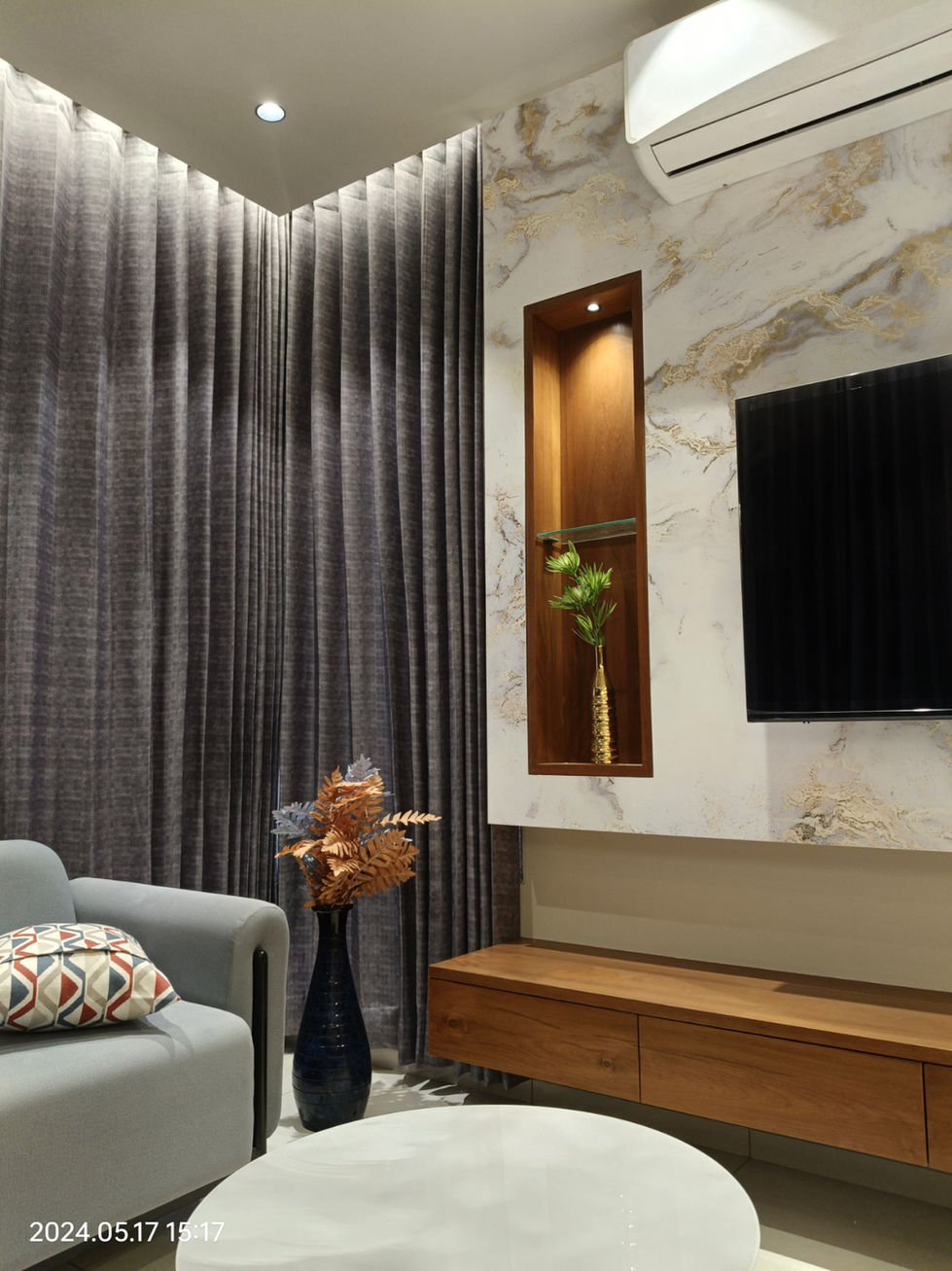 Modern living room with gray curtains, TV, and wooden media console