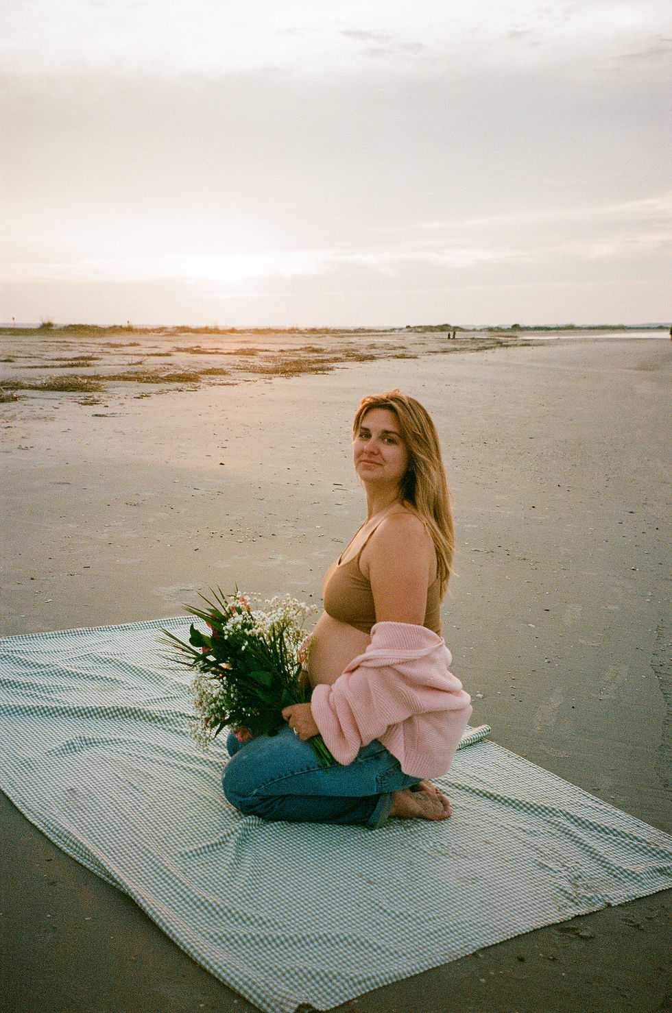 Pregnant Woman on beach with flowers