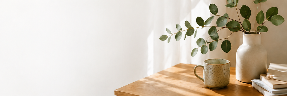 Eucalyptus in a vase and a ceramic mug on a wooden table in a clean participants home