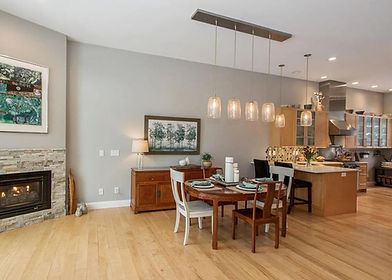 Before interior painting: warm-toned open living space and kitchen with older wall color and uneven light reflection, ready for MTM interior painting services.