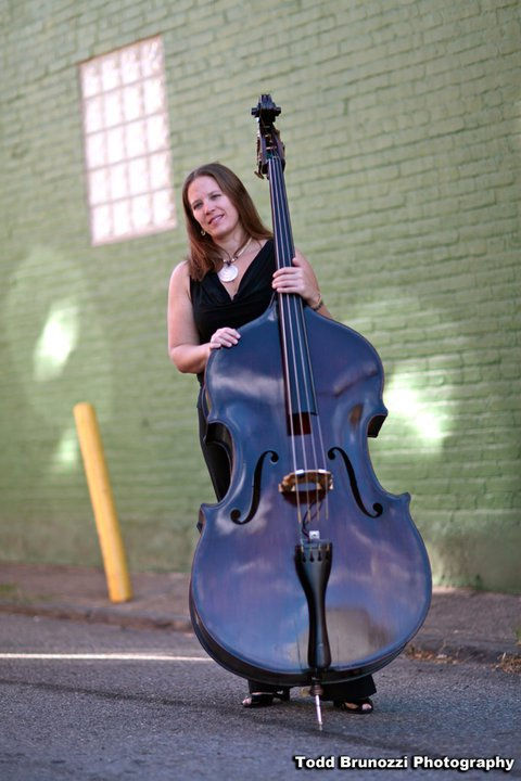 Trish Imbrogno with her upright bass, Sheldon, a handcrafted Rumano Solano model featured on her bluegrass EP Bluegrass Love Songs, Volume One, known for its rich, warm tone.