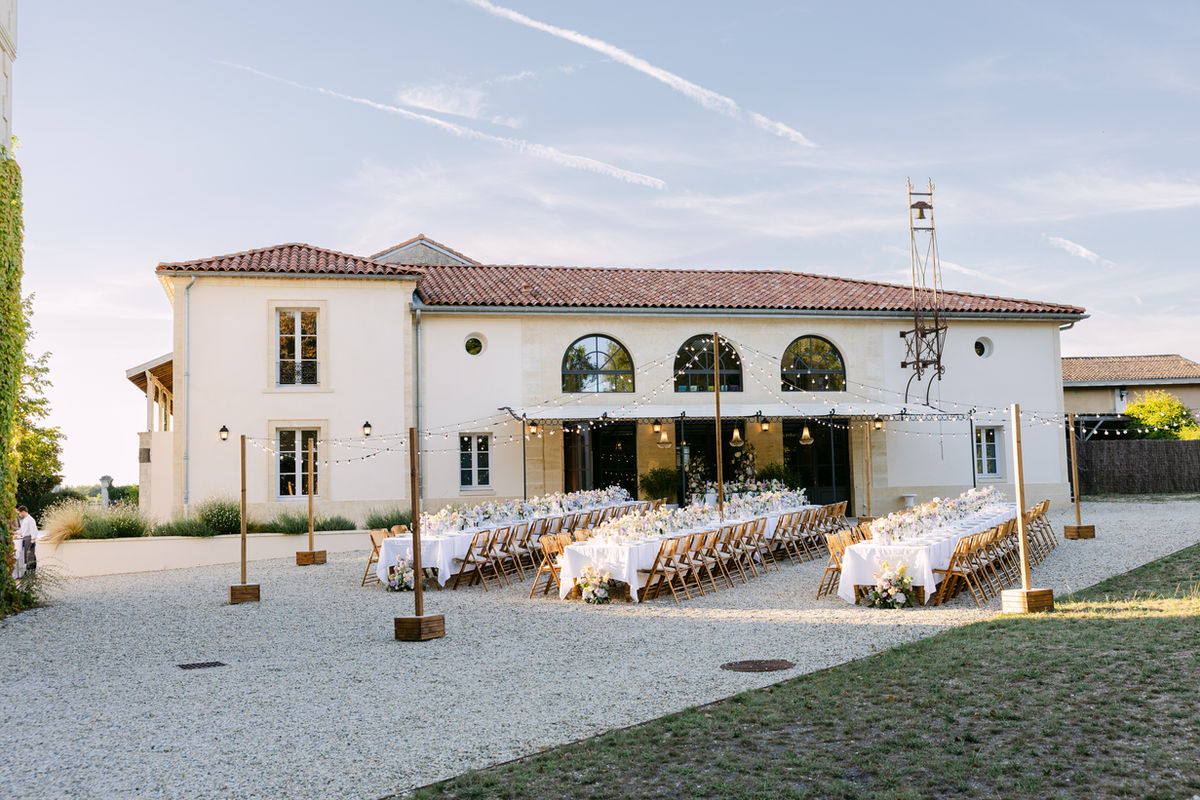 An outdoor wedding reception dinner in the courtyard at Château Sénéjac