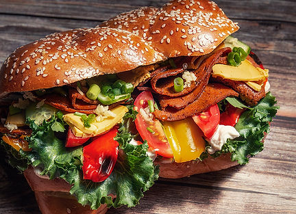 לחמנייה מתוקה עם נקניק טבעוני מעושן פרוס, גבינת גאודה טבעונית, איולי שום טבעוני