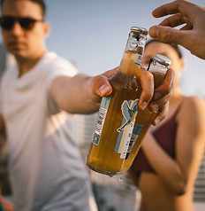Man handing drink to camera man