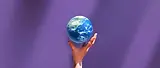holding up a globe purple background.webp